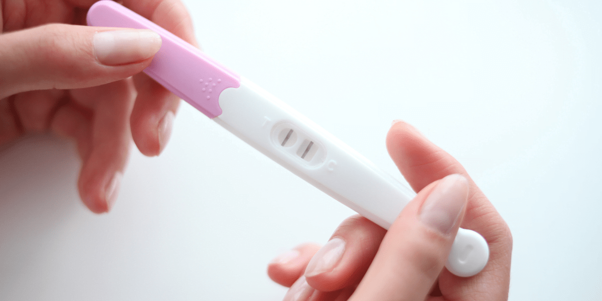 Pregnany test with two lines being held